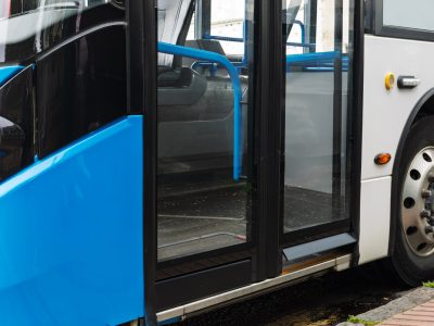 Close-up of the closed door of a modern city bus. Concepts for public transport, urban mobility, commuting, and accessibility in city life